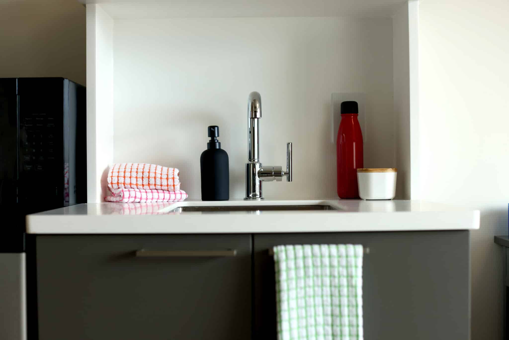 A kitchenette with a sink, cabinet, and countertop